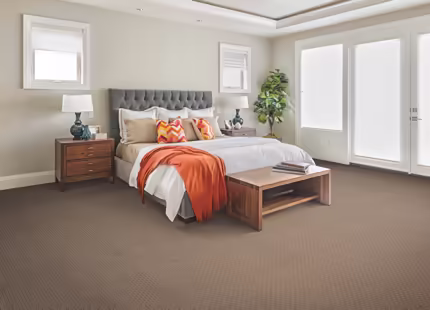 A bedroom with a bed, dresser, and two windows